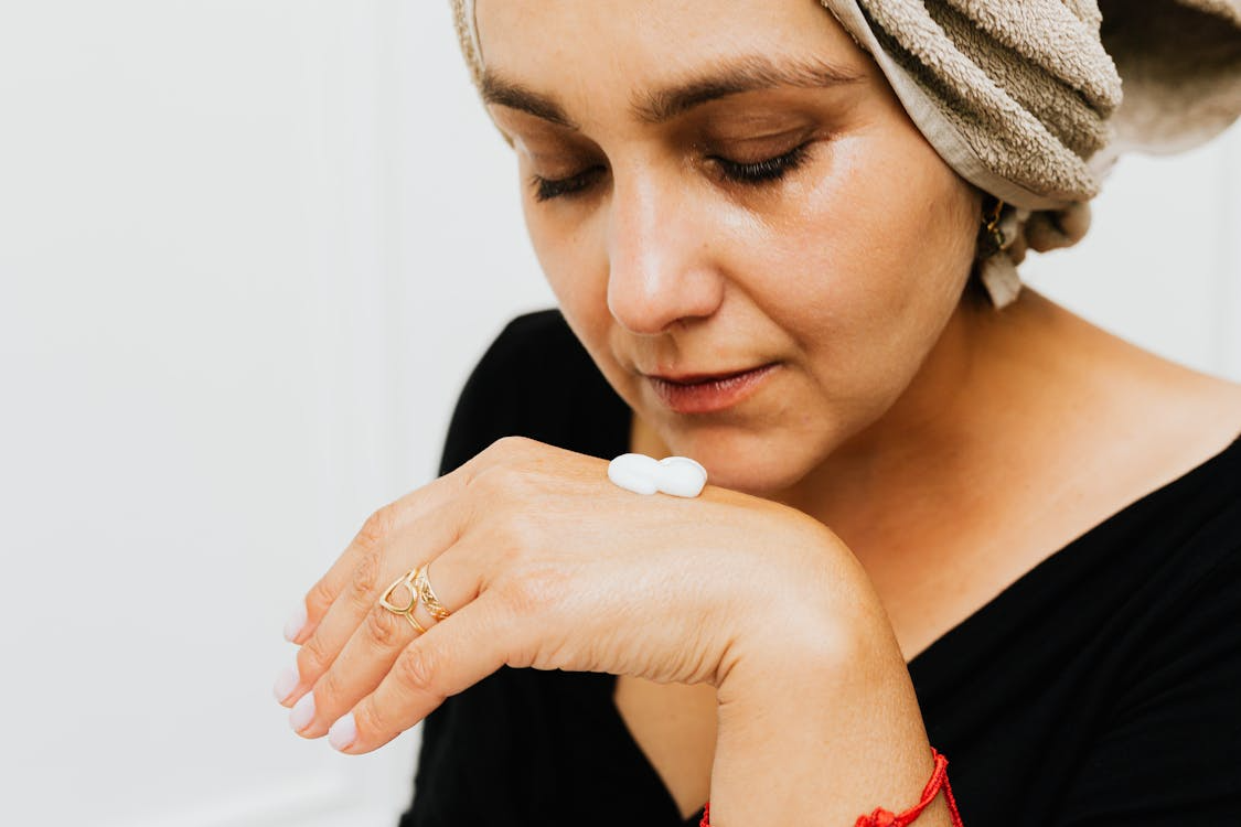 A woman over 60 testing a skincare cream on her hand