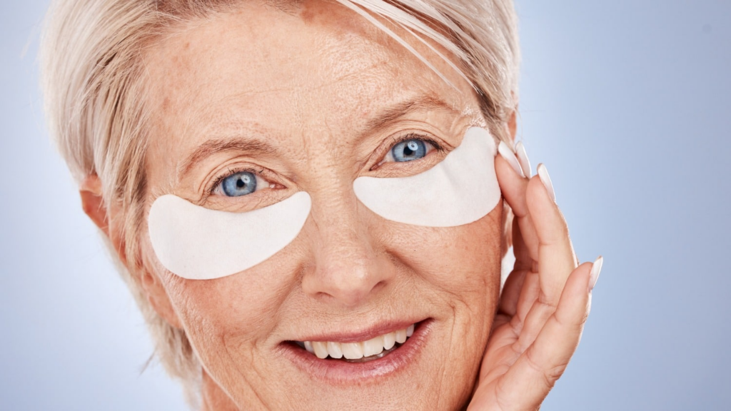 Woman over 60 wearing hydrating under-eye patches