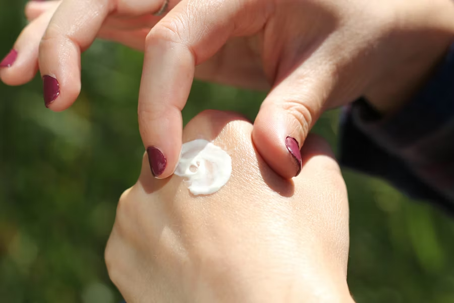 Close-up of hands applying moisturizing cream for dry skin