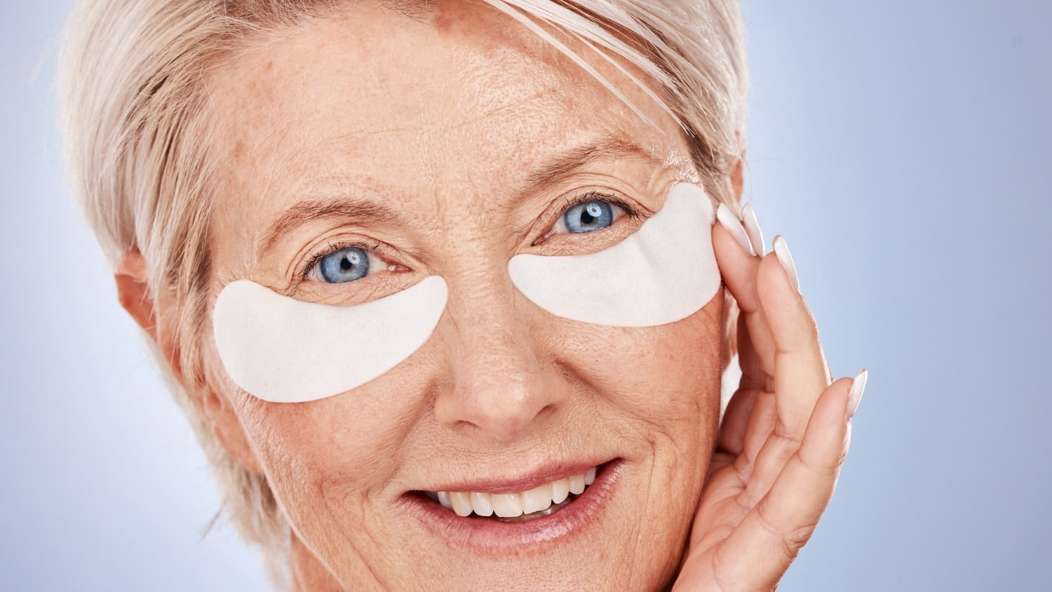 Mature woman using eye patches as part of a relaxing evening skincare routine for healthier-looking skin